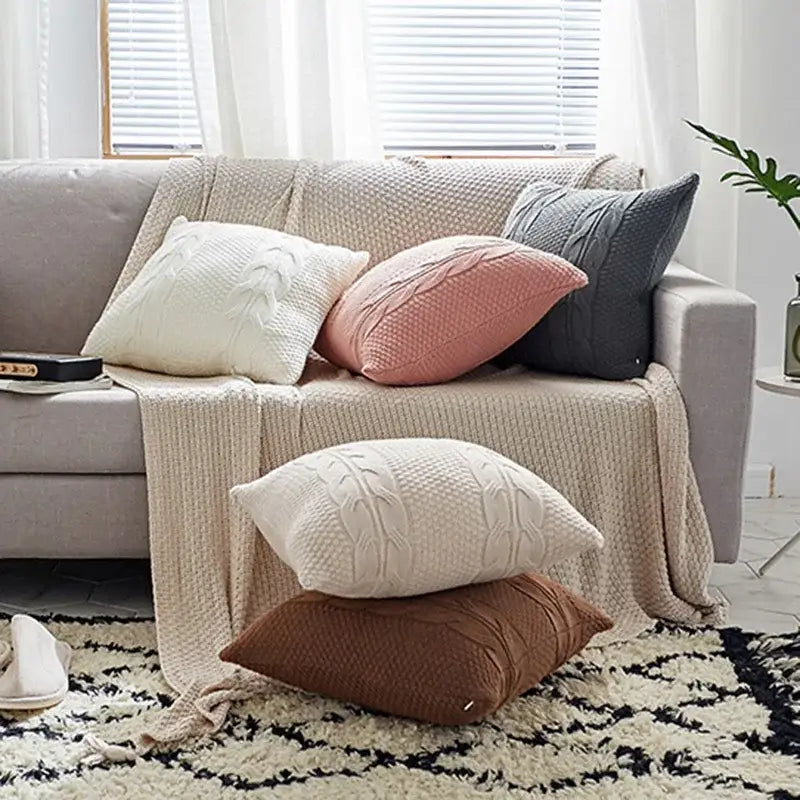 Set of double cable knit cushion covers in cream blush pink charcoal gray and brown tones for living room use