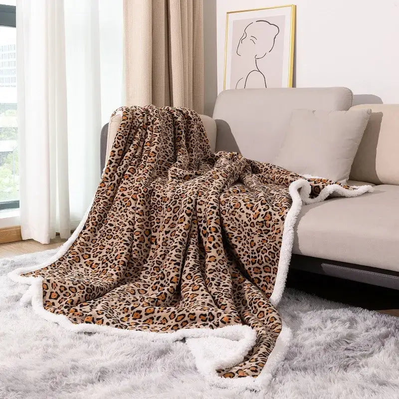 A double layer leopard print coral fleece blanket with plush texture and soft white fleece border for bedroom use
