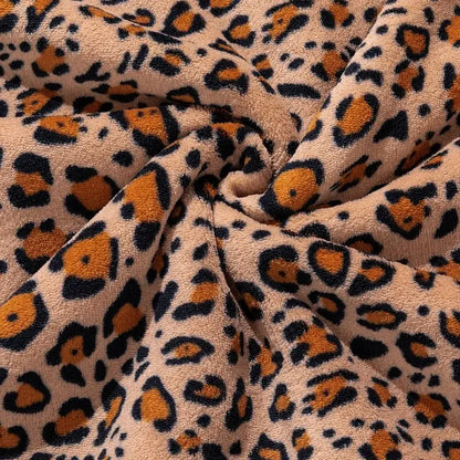 Double layer leopard print coral fleece blanket with tan base and bold orange and black faux fur pattern for bedroom use