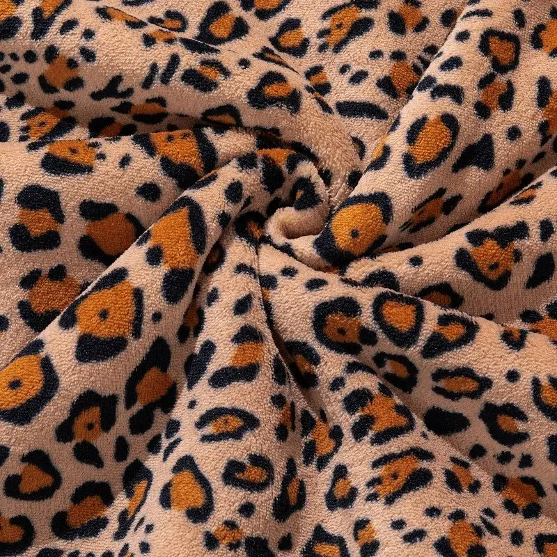 Double layer leopard print coral fleece blanket with tan base and bold orange and black faux fur pattern for bedroom use
