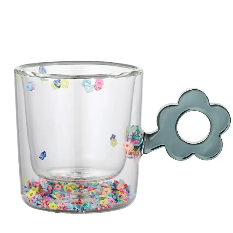 Clear double wall glass mug with a matte gray flower handle and colorful glitter flowers for kitchen and dining room use