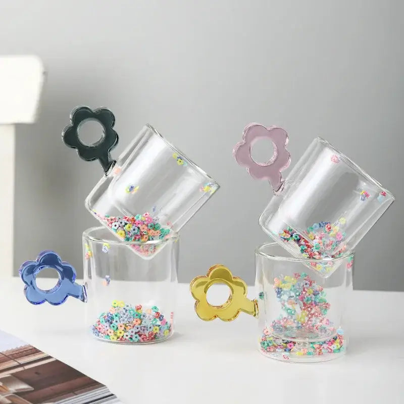 Double wall glass mugs featuring clear tumblers with glitter flowers in black pink blue and gold for kitchen use