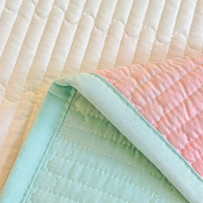Pastel pink and mint green quilted dreamy gradient single bedspread made of soft cotton fabric with subtle stitched patterns