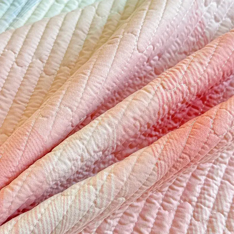 A decorbites dreamy gradient single quilted bedspread in pink with satin texture and subtle diagonal stitching