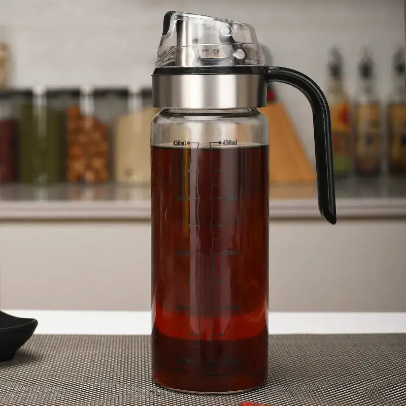 Clear glass durable automatic oil bottle with stainless steel lid and black handle marked 450ml for kitchen storage