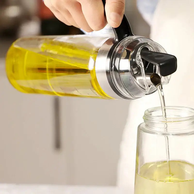 Durable automatic oil bottle in clear glass with black handle and silver cap filled with golden-yellow cooking oil for kitchen storage