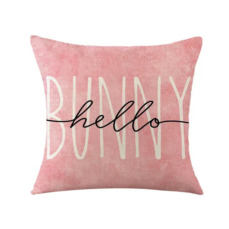 Pink cushion cover with bunny hello in white block and black cursive on easter bunny rabbit linen fabric