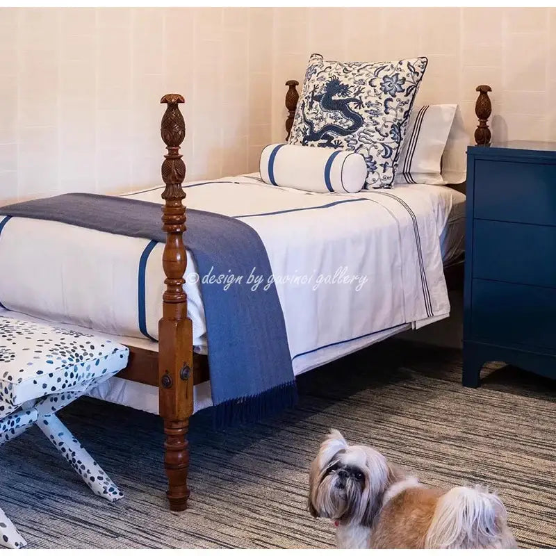 Wooden four-poster bed with dark brown carved posts and indigo blue decorbites indigo blue pillow cover accents