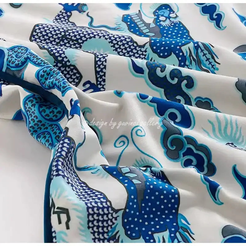 A flowing white silk scarf with intricate blue dragon and cloud motifs complements decorbites indigo blue pillow cover decor