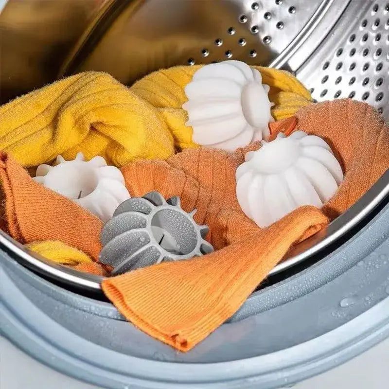 Eco-friendly laundry washing starburst balls gray and white pods nestled among colorful towels in washing machine drum