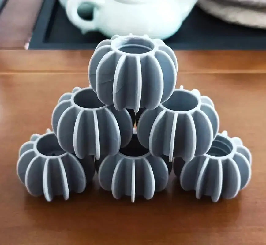 Gray ribbed silicone protective caps for table legs featured in an eco-friendly laundry washing starburst balls 10-piece set