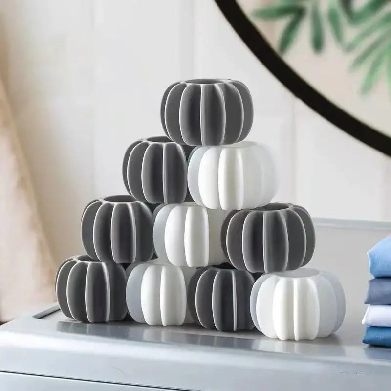 Stack of gray and white pumpkin-shaped silicone coasters with eco-friendly laundry washing starburst balls 10-piece set