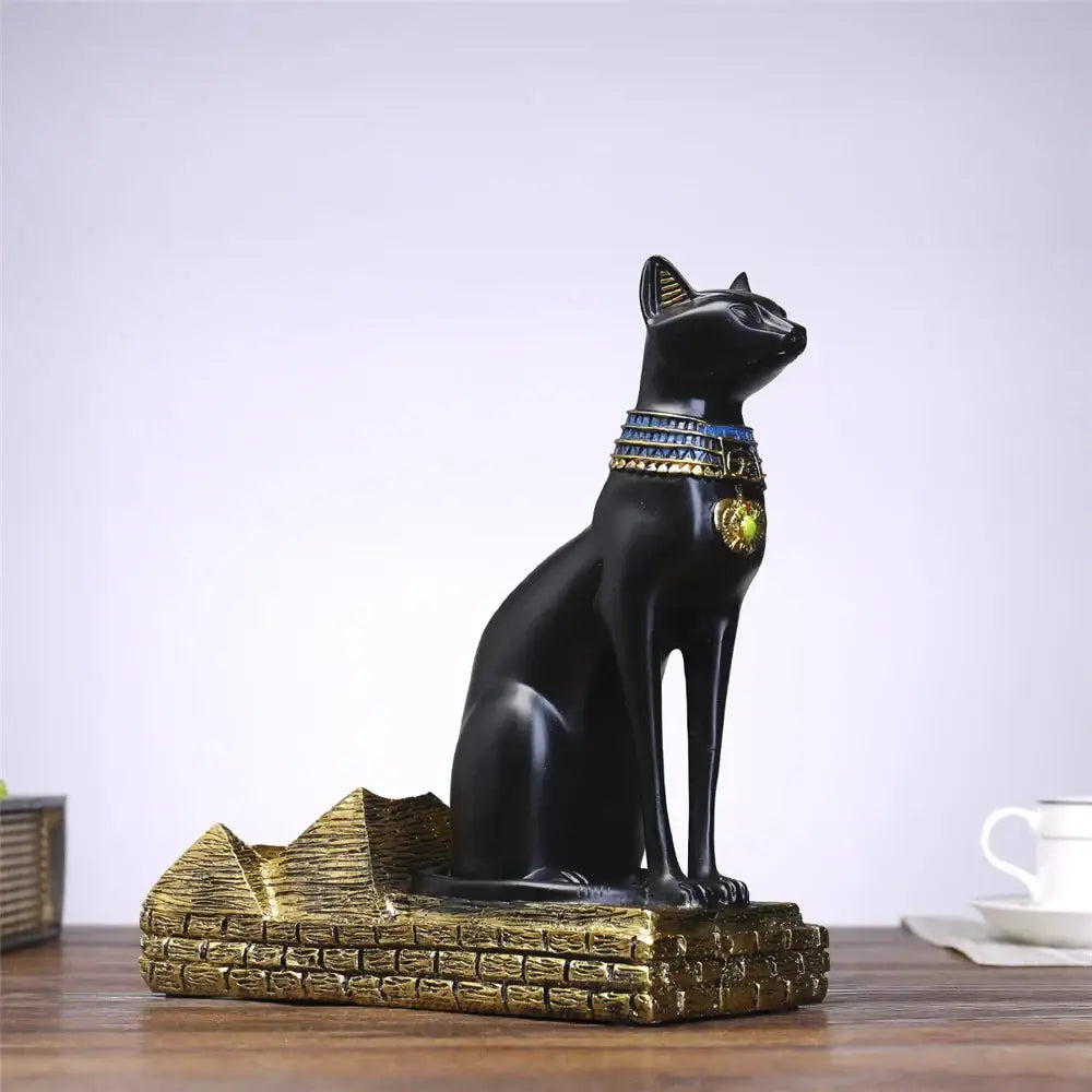 Black resin egyptian cat wine bottle holder with gold and blue collar on golden pyramid base for dining room decor