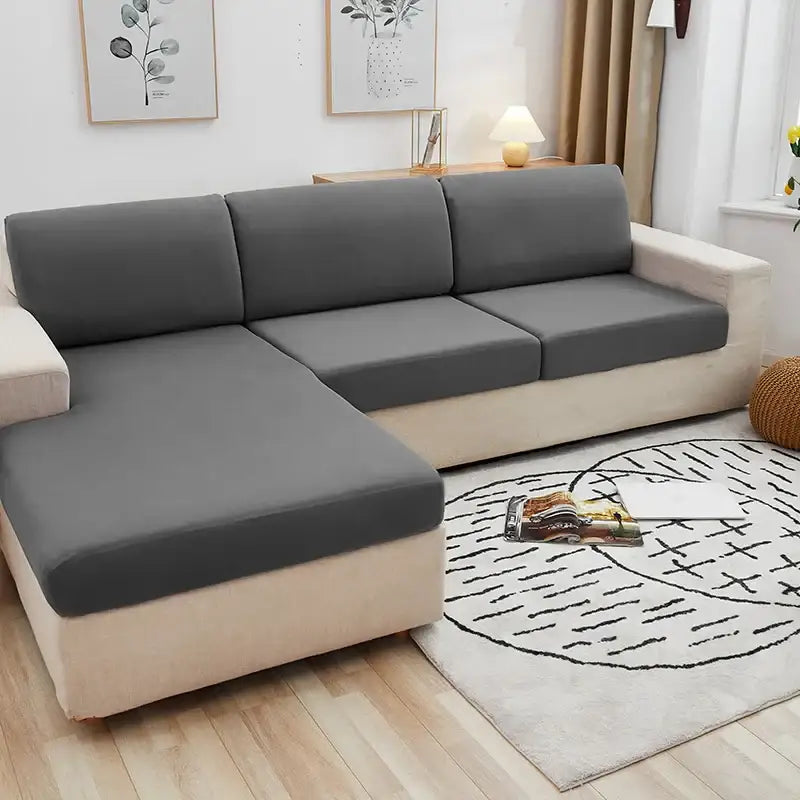 Gray fabric sofa cover snugly fitted over a beige sectional sofa.