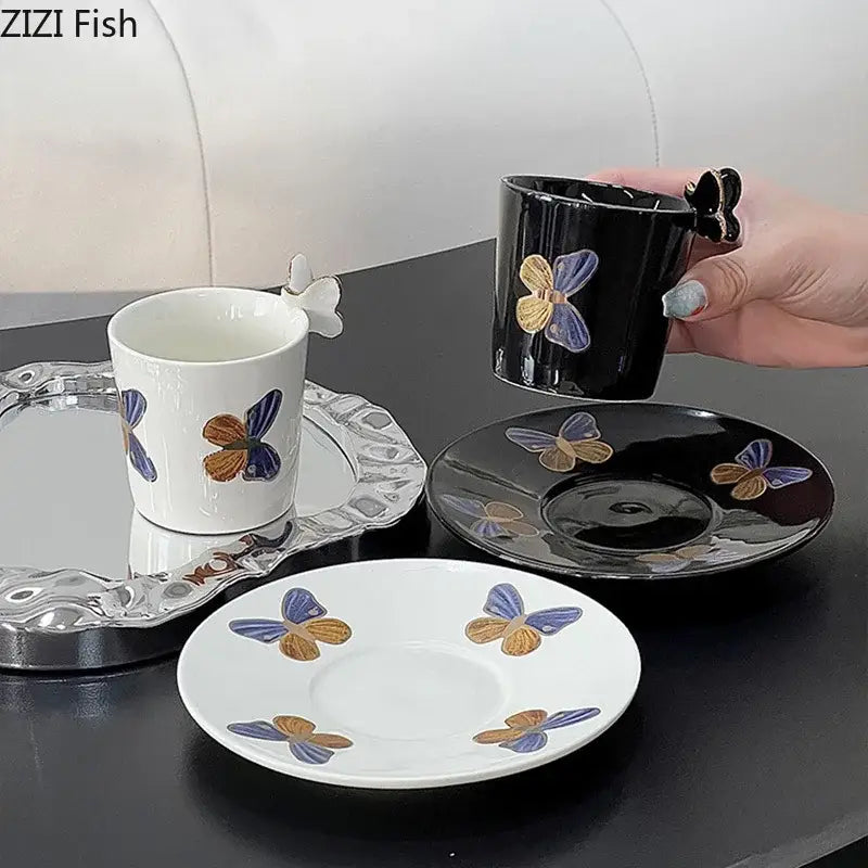 Elegant black ceramic tea cup with butterfly handle and gold-blue painted butterflies paired with matching saucer