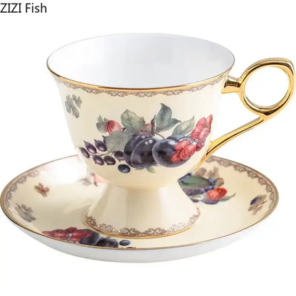 Cream-colored porcelain teacup and saucer with gold trim featuring a delicate decorbites fruits pattern ceramic design