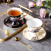 Elegant black and cream fruits pattern ceramic tea set with gold-trimmed floral cups and saucers by decorbites fruits pattern