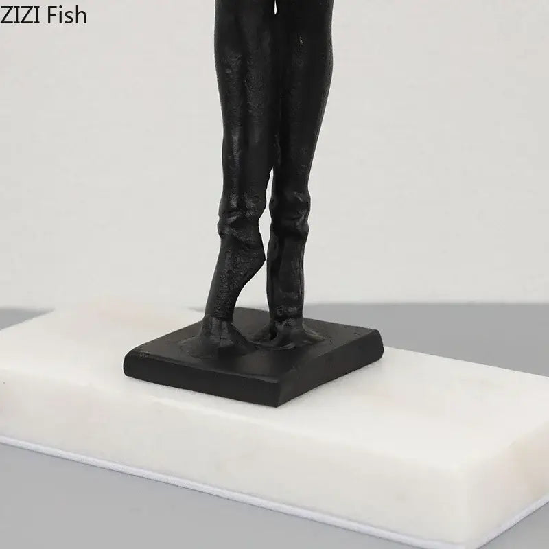 Elegant black sculpted ballerina sculpture of legs in formal attire on white marble plinth with gold accents bedroom decor