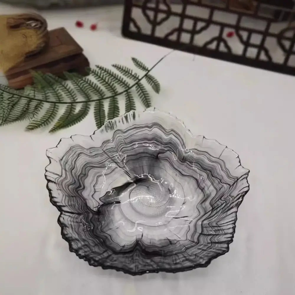 A translucent glass plate with black and gray marbled pattern and organic leaf-like rim from decorbites elegant flower collection