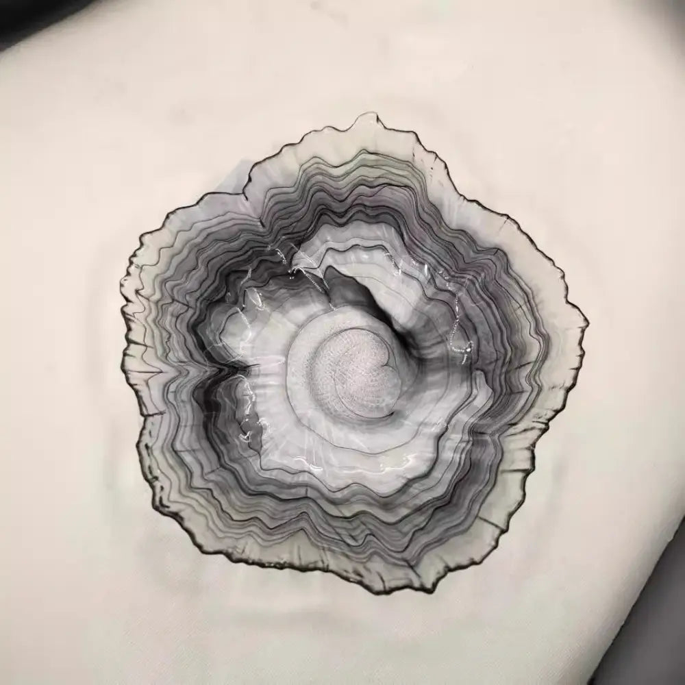 A sleek black and gray agate glass plate with concentric rings, perfect for decorbites elegant flower glass snack dish