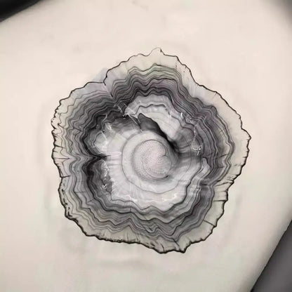 A sleek black and gray agate glass plate with concentric rings, perfect for decorbites elegant flower glass snack dish
