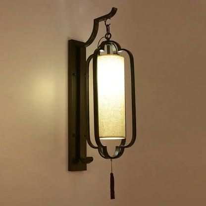 Dark bronze-finished wall sconce lamp with rectangular lantern frame and warm fabric shade for elegant bedroom lighting