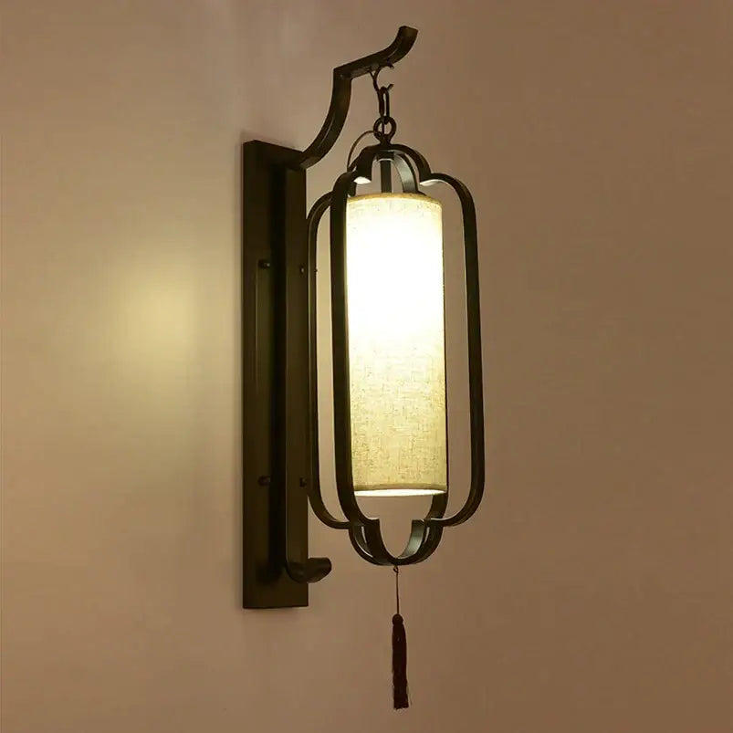 Dark bronze-finished wall sconce lamp with rectangular lantern frame and warm fabric shade for elegant bedroom lighting