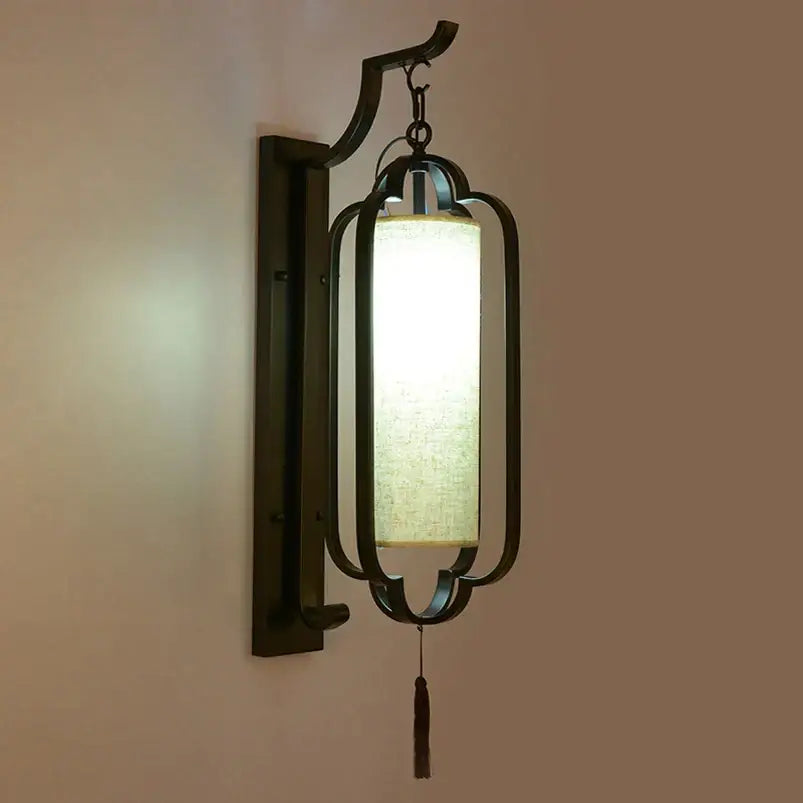 Elegant black wrought iron wall sconce lamp with a rectangular off-white fabric shade and a dark tassel for bedroom lighting