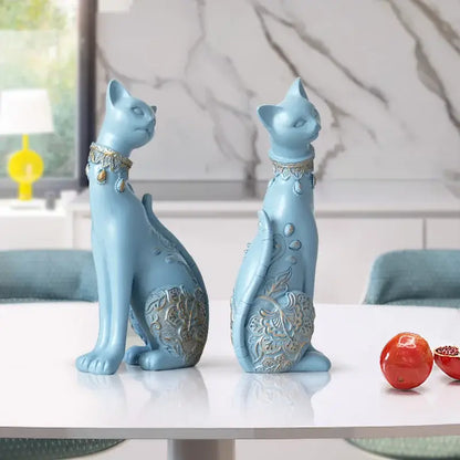 Two light blue ceramic decorbites cat statues with gold-toned collars and floral embossed patterns for living room decor