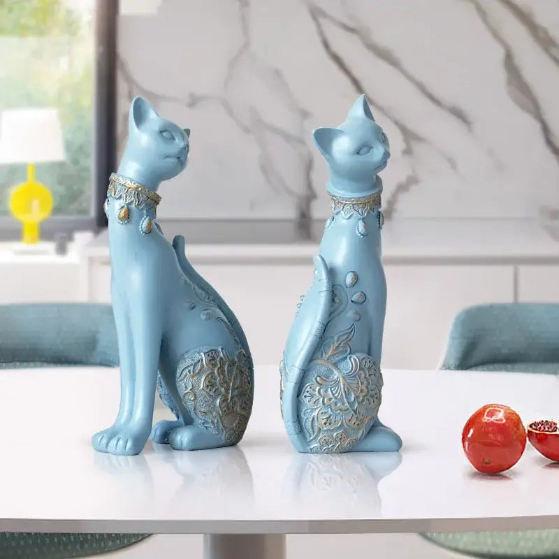 Two light blue ceramic decorbites cat statues with gold-toned collars and floral embossed patterns for living room decor