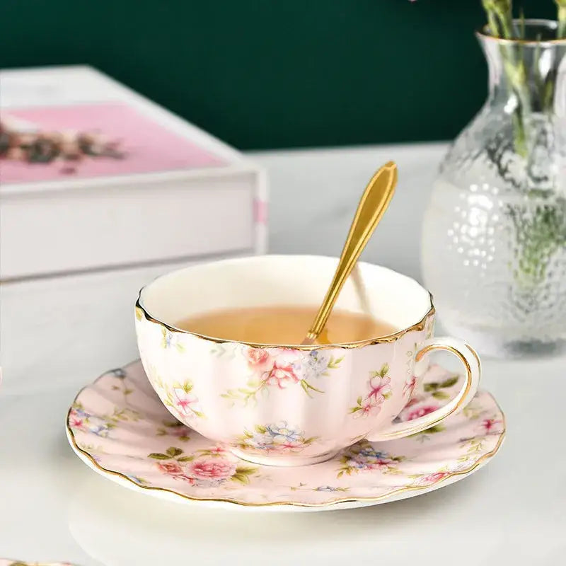 Elegant blue and pink floral porcelain tea cup set featuring a delicate pink tea cup with gold trim on matching saucer