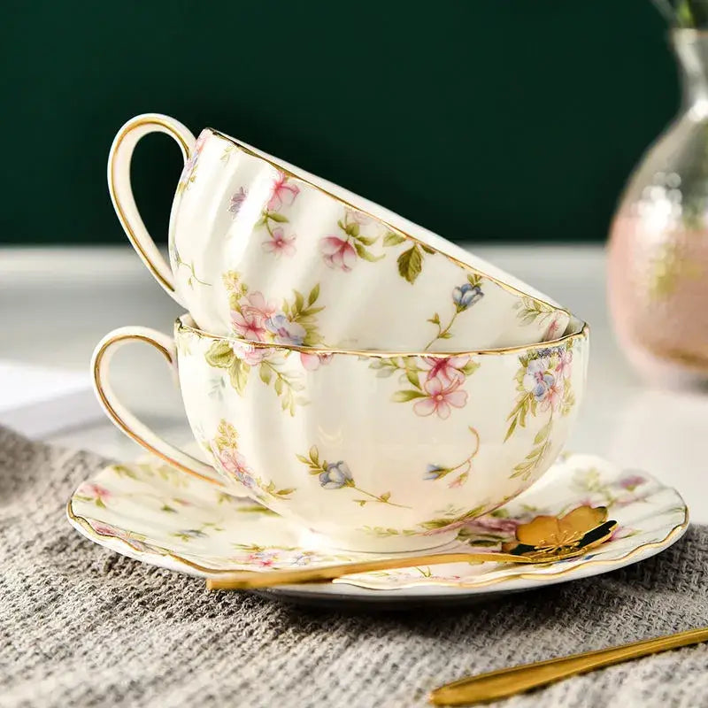 Elegant blue and pink floral porcelain tea cup set featuring delicate white cups with gold trim for dining room use