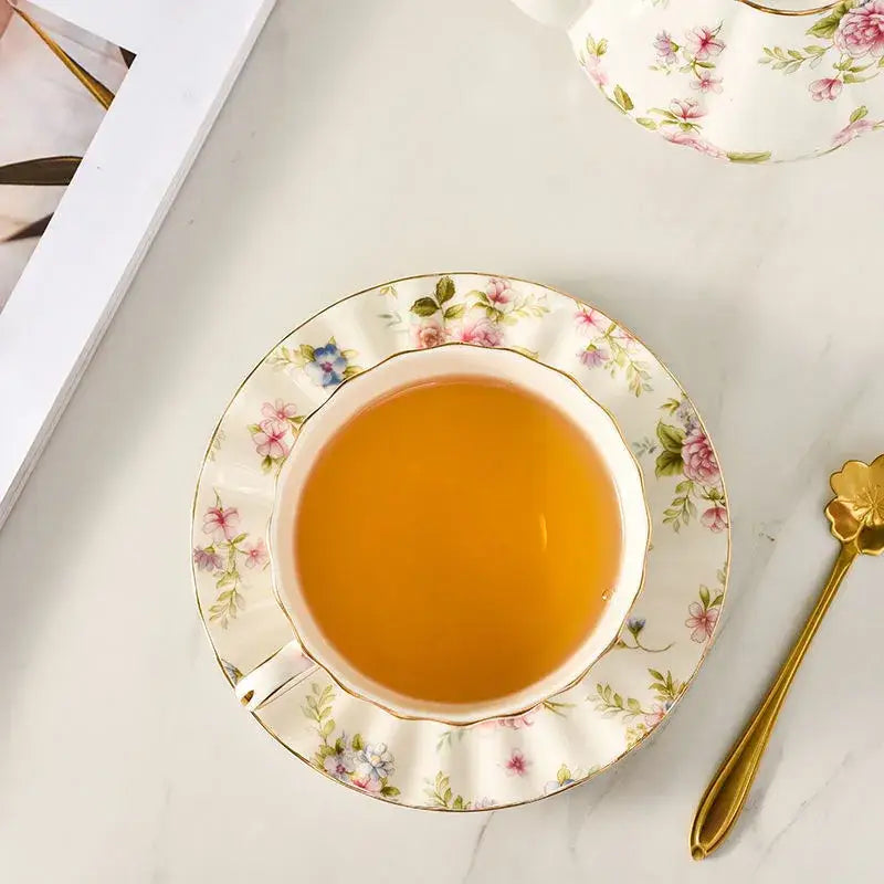 Elegant blue and pink floral porcelain tea cup set with gold trim on ivory background for dining room use