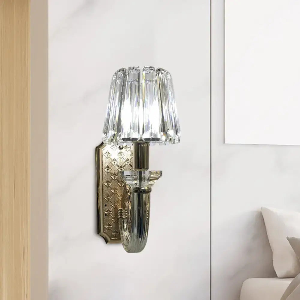 Elegant brass and crystal tapered cone sconce light with crystal-encrusted curved arm and polished brass backplate for bedroom