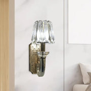 Elegant brass and crystal tapered cone sconce light with crystal-encrusted curved arm and polished brass backplate for bedroom