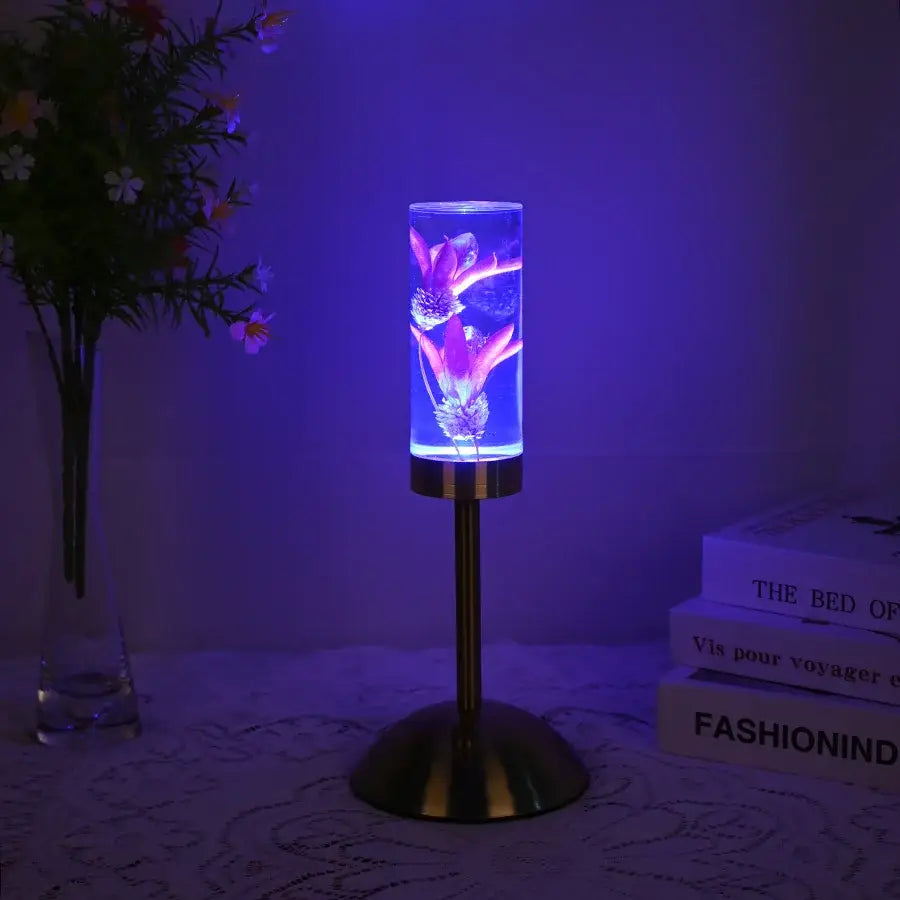 Elegant brass decorbites eternal flower desk lamp with a cylindrical glass shade and purple glowing eternal flower acrylic