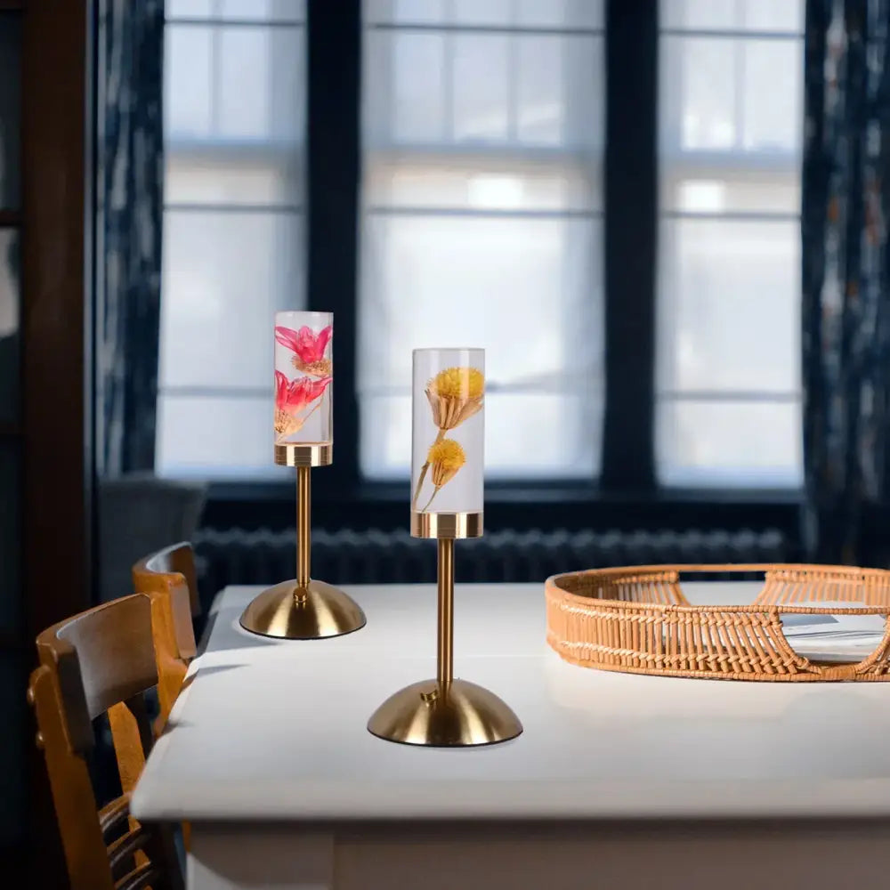 Two elegant brass desk lamps with decorbites eternal flower acrylic tops featuring pink and yellow preserved blooms