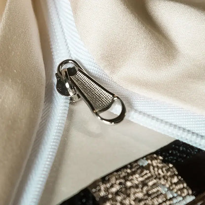 Silver-toned metal zipper pull with textured grid surface on elegant brown and cream 200s embroidery egyptian cotton bedding set