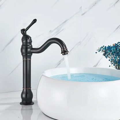 Elegant black matte single handle sink faucet with curved spout and ornate detailing beside white ceramic sink