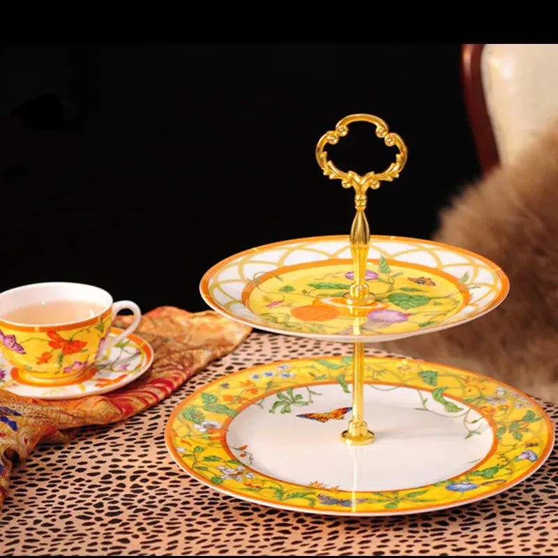 Two-tiered dessert stand with ornate gold handle and yellow floral porcelain plates from butterfly kitchen tableware set
