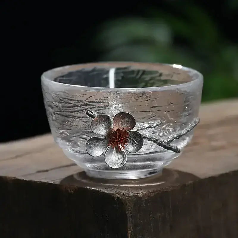Elegant carved tin glass tea cup set featuring clear textured glass and ornate silver flower accent with red center
