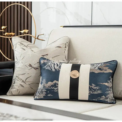 Elegant navy blue cushion with intricate mountain and bird embroidery featuring a bold cream stripe band and gold button decorbites dragonfly insects