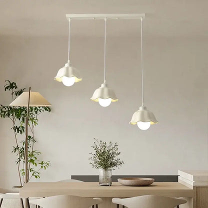 Three white pendant lights with fluted shades hang from a rectangular mount in the decorbites elegant cream led chandelier