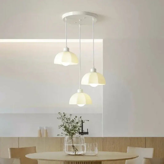 Three cream led chandelier dome pendant lights with glass shades hanging from a white ceiling fixture for dining room decorbites elegant cream