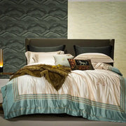 Cream-colored satin duvet cover with teal border and monogram in decorbites 1200tc egyptian cotton bedding set