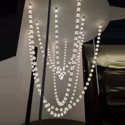 A modern decorbites elegant pendant chandelier with clear faceted glass beads and gold accents for staircase lighting