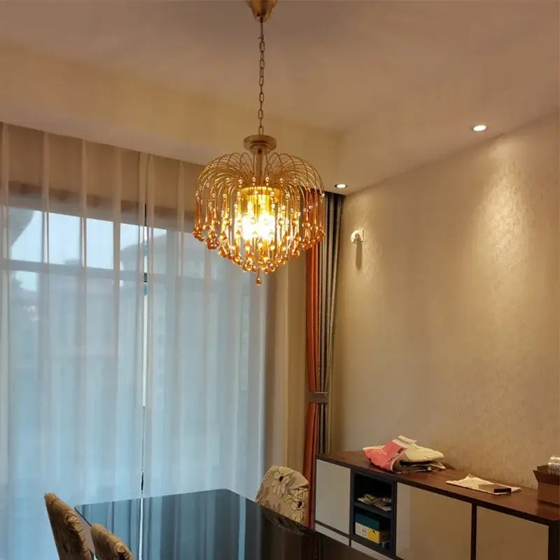 Elegant crystal ceiling chandelier with amber and clear cascading crystal droplets and warm glowing light for dining room decorbites elegant crystal