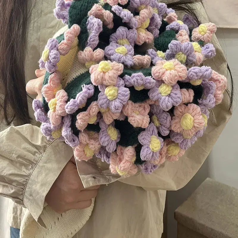 Elegant daisy bouquet soft knitted blanket with pastel purple pink and yellow crocheted flowers on dark green base