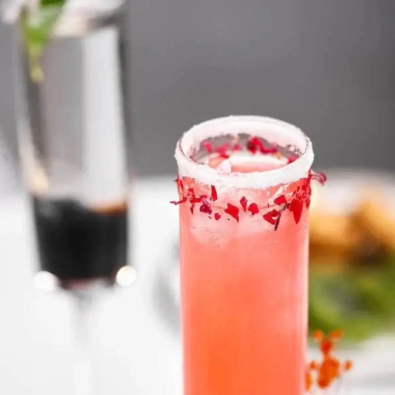Elegant dried flower bubble champagne glasses set of 2 with vibrant pink cocktail rimmed with white sugar and red petals