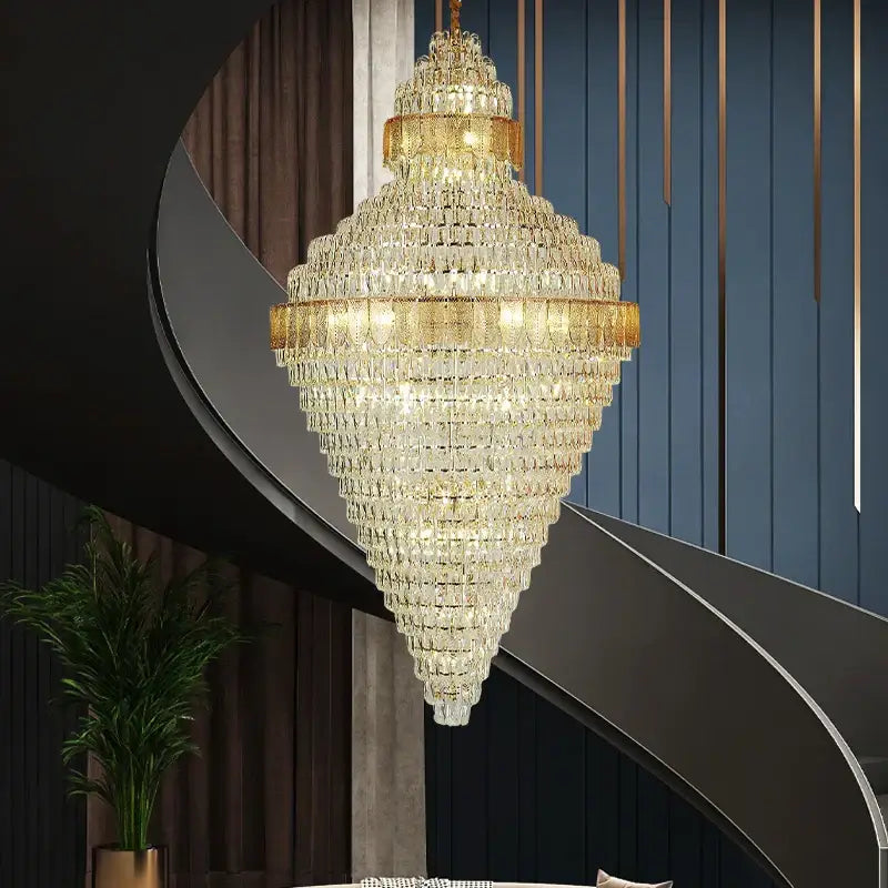 A luxurious gold-toned elegant duplex crystal chandelier with faceted glass tiers above a modern staircase decorbites elegant duplex